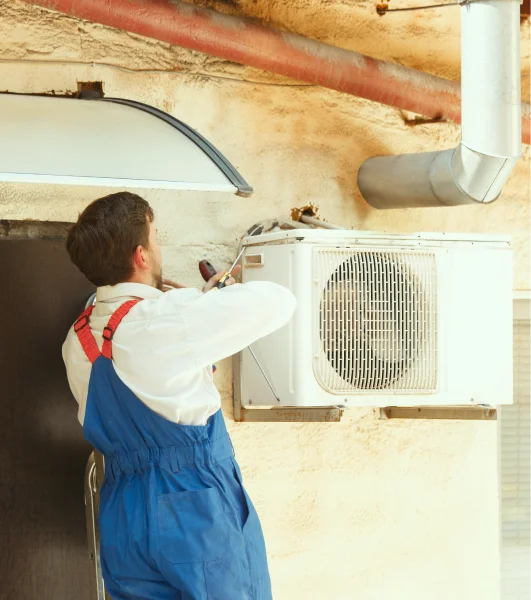 A man is working on an air conditioning unit.